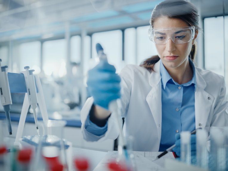 Eine Forscherin arbeitet mit einer Pipette.